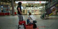 Ein Mann und eine Frau warten Münchener Hauptbahnhof auf einen Zug