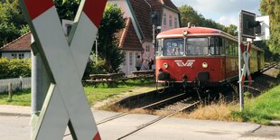 Roter Linienzug steht vor Bahnhofsgebäude