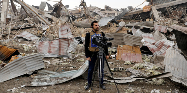 Ein Filmjournalist steht in Trümmern nach einem Bombenanschlag in Kabul.