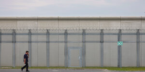 Ein Mitarbeiter geht an den Sicherheitsanlagen der neuen Abschiebehaftanstalt in Glückstadt entlang