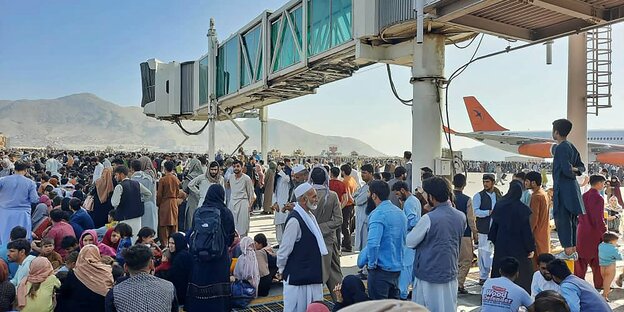 Menschen warten auf dem Rollfeld des Kabuler Flughafens