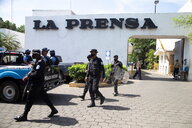Polizisten kommen aus einem Tor auf dem La Prensa in großen Lettern steht