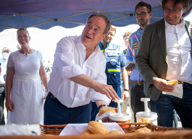 Armin Laschet drückt sich Ketchup auf die Wurst im Brötchen