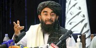 Ein Talib mit Bart und Turban gibt seine erste Pressekonferenz nach der Machtübernahme