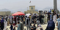 Menschen stehen vor dem Flughafen in Kabul