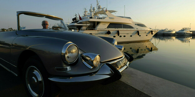 ein großes Cabrio steht vor eine Luxusjacht