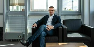 Jens Spahn auf einem Sessel in einem Büro mit Blick auf den Berliner Fernsehturm