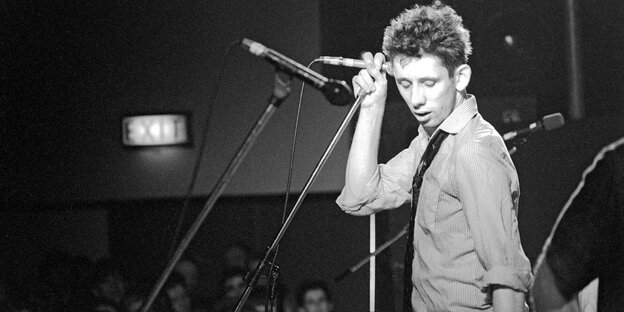 Shane MacGowan am Mikrofon auf der Bühne, 1988