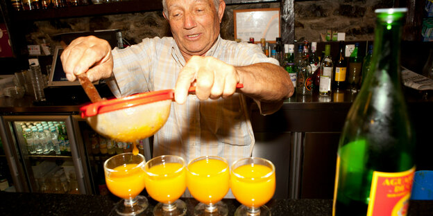 Ein Barmann bereitet einen goldgelben Drink zu
