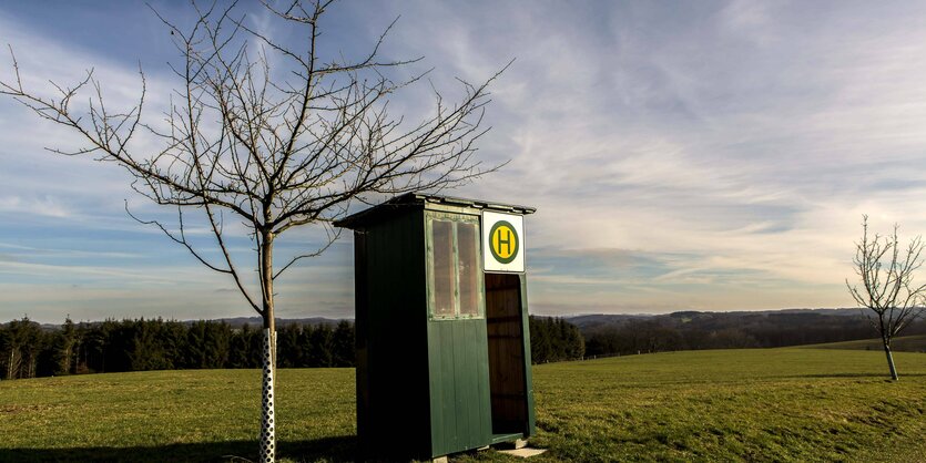 Winziges Wartehäuschen und Haltestelle mit Landschaft