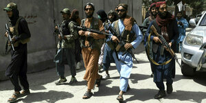 Taliban mit Sonnenbrillen und Waffen patroullieren