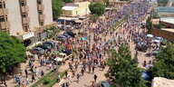 Aufnahme aus der Vogelperspektive: Hunderte Menschen auf einer Straße.