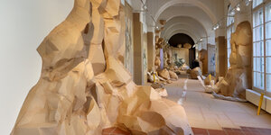 Innenansicht der Galerie im Körnerpark: An den linken Wänden wandern Formationen aus Pappe bis unter die Decke, der Boden ist mit Papier ausgelegt, Papierobjekte sind im Raum verteilt