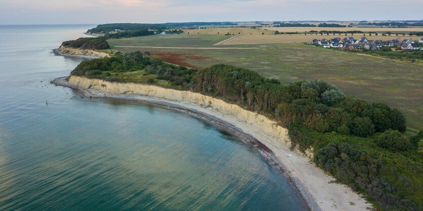 Drohnenaufnahme: Meer und Küste und ein kleines Dorf von oben