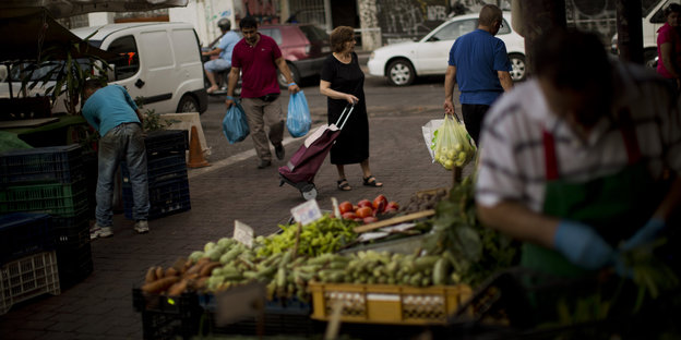 Eine Frau kauft auf einem Markt in Athen ein