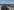 Große Plattenbauten in Marzahn vor der Skyline von Berlin. Sie haben flache Dächer