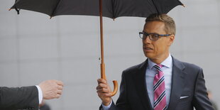 Finnlands Finanzminister Alexander Stubb unterm Regenschirm