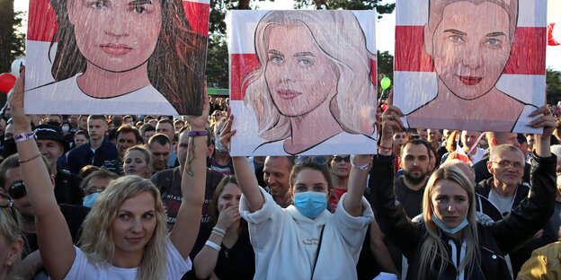 Protestierende in Belarus halden Schilder hoch.