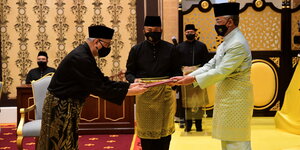 Der neue Premierminister Yakoob verbeugt sich und nimmt ein Dokument vom König entgegen