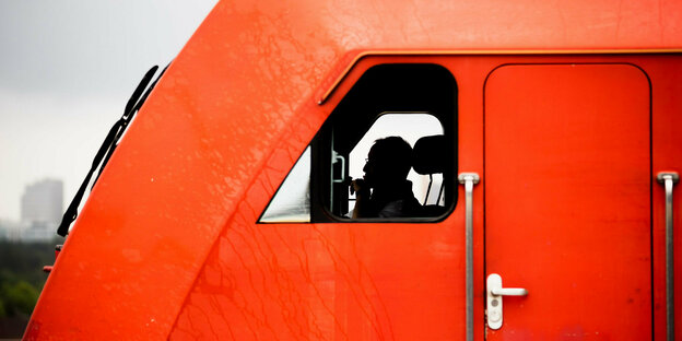 Rotes Führerhäuschen eines Güterzugs, seitlich fotografiert.