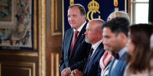 Stefan Löfven steht ganz außen in einer Reihe Menschen, als einziger scharf gestellt.