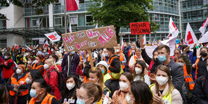 Menschen demonstrieren vor einer Klinik