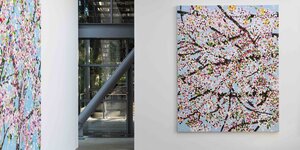 Zwei Bilder mit Kirschblüten hängen über Eck, wobei die aus Glas ist und den Blick in den Garten freigibt