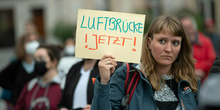 Frau hält ein Schild hoch "Luftbrücke jetzt !!"