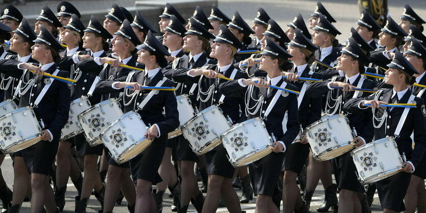 Menschen in Uniform marschieren mit Trommeln