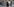 Eine Frau mit Kindern schleppt einen Sack vor einer Muelldeponie