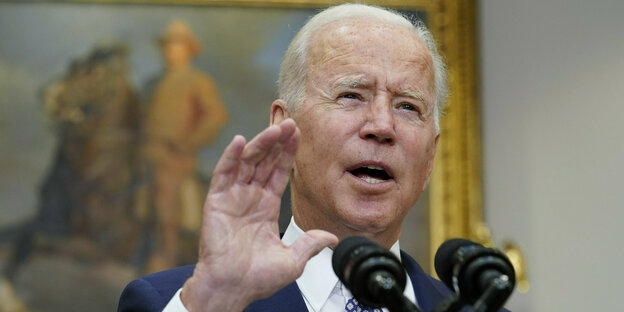 Joe Biden spricht ins Mikrophon und gestikuliert