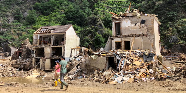 2 zerstörte kleine Häuser vor einem Weinberg