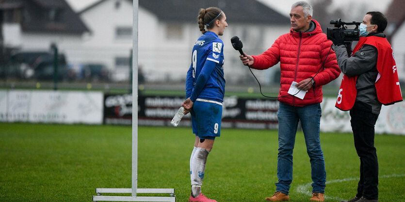 TV-Interview auf dem Sportplatz des SC Sand vor einer Sponsorenwand