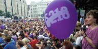 lila Ballon mit einem durchgestrichenen &218 schwebt über einer Menschenmenge