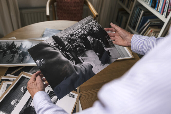 Die Hände von Engelbert Reineke halten ein großes schwar-weiß-Foto, auf dem der Kniefall von Willy Brandt zu sehen ist