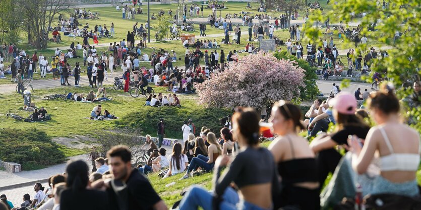 Menschen stehen und sitzen im Mauerpark