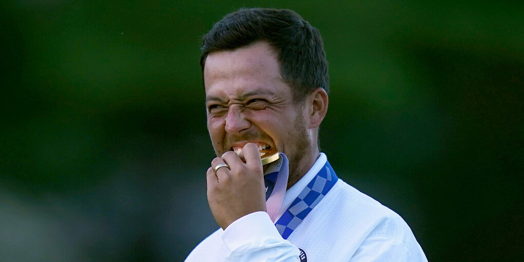 US-Golfer Xander Schauffele beißt bei der Siegerehrung auf die Goldmedaille