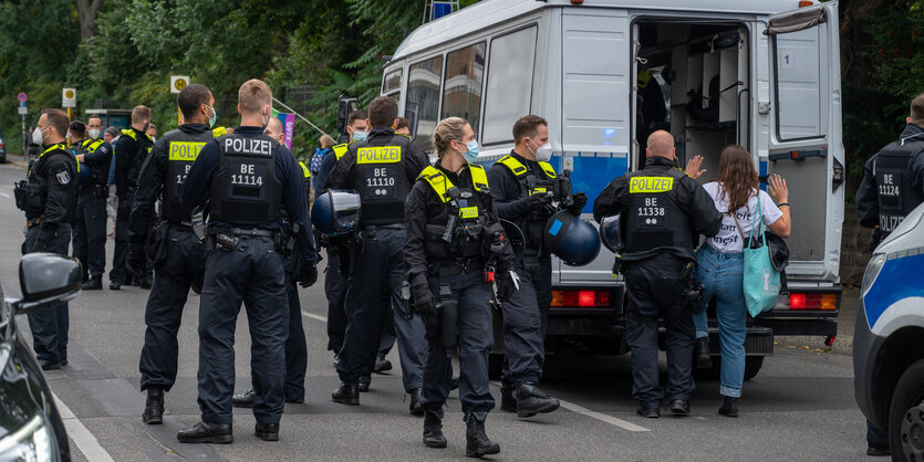 Demonstranten laufen in Berlin, einer trägt eine Deutschlandflagge als Umhang