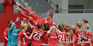 Die Bayern-Frauen bejubeln in einer Traube die Meisterschaft und lassen ihre Kapitänin hoch leben