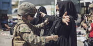 Soldatin kontrolliert Frau