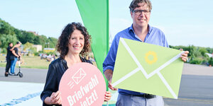 Bettina Jarasch und Michael Keller stehen mit Briefwahlplakaten auf dem Tempelhofer Feld