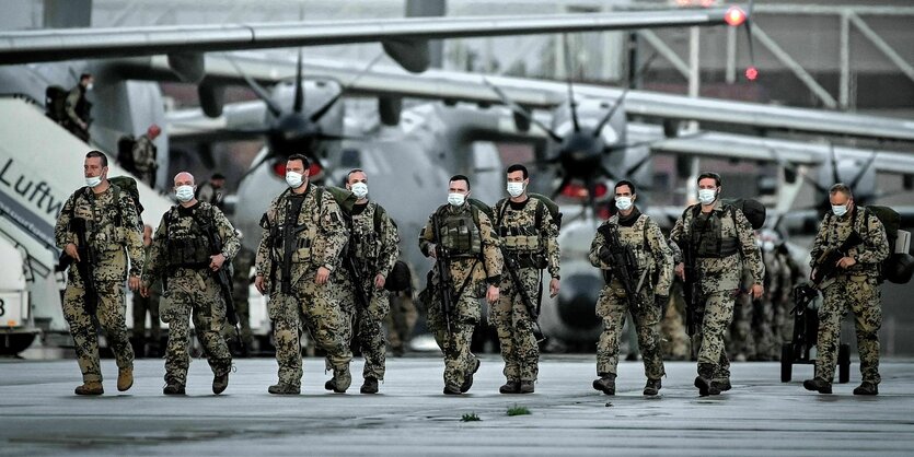 Bundeswerhsoldaten verlassen einen Airbus auf einem Fliegerhorst.