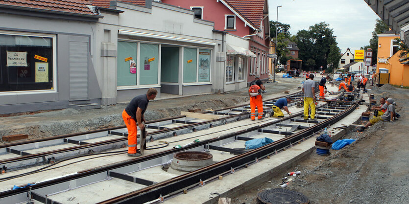 Bauarbeiter beim Bauen einer Trambahn-Trasse