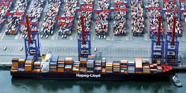 Ein Containerschiff von Hapag Lloyd steht an einem Containerterminal.