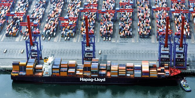 Ein Containerschiff von Hapag Lloyd steht an einem Containerterminal.