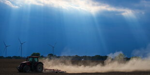 Ein Traktor zieht eine Staubfahne hinter sich her