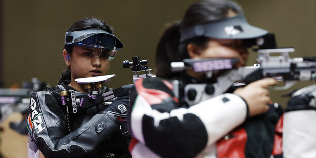 Paralympics-Siegerin im Luftgewehrschißen beobachtet ihre Konkurrentin am Schießstand