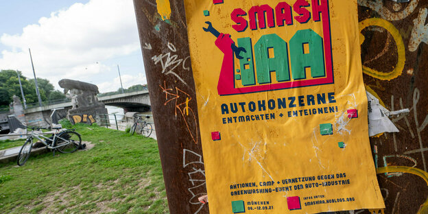 Gegner der Automesse IAA Mobillity haben ein Plakat aufgehängt "Smash IAA" auf knalligem Gelb. Autokonzerne entmachten+enteignen