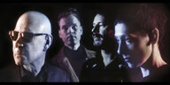 Nahaufnahme der vier Bandmitglieder der Band KUU! vor einem dunklen Hintergrund, drei Bandmitglieder schauen nach links, der zweite Mann von links schaut in die Kamera