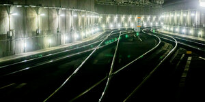 Bahngleise in einem beleuchteten Tunnel